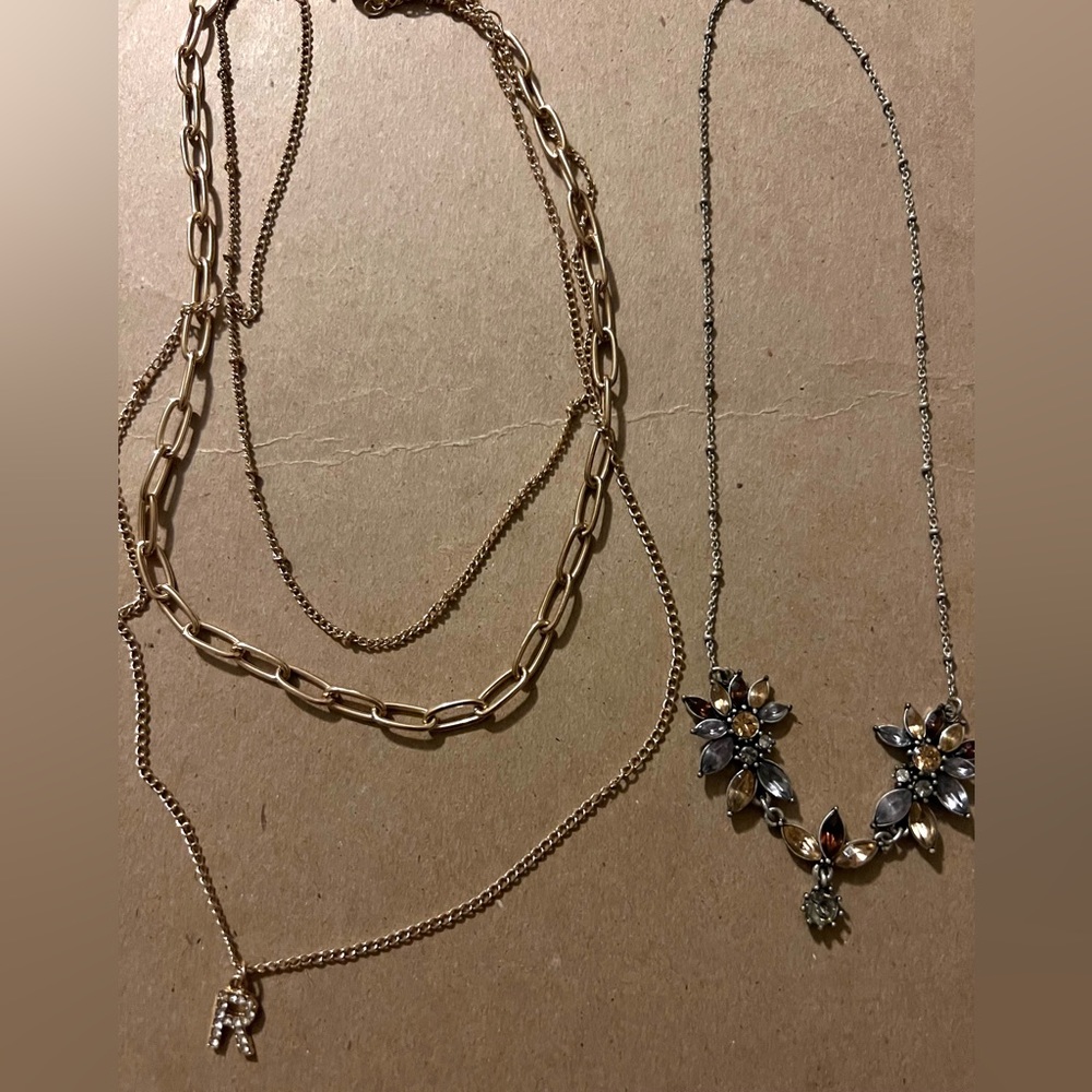 2 necklaces. Gold with R letter and flower necklace